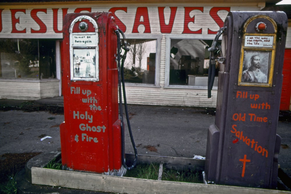 two old fashioned gas pumps in front of a church