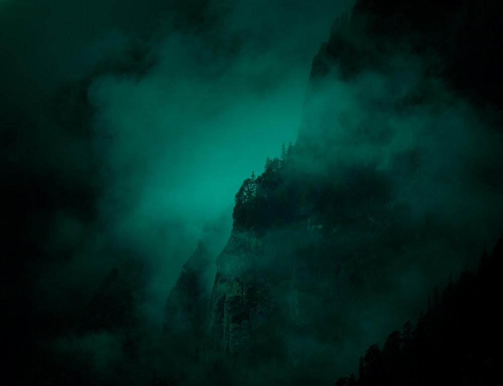 a mountain covered in fog and green light