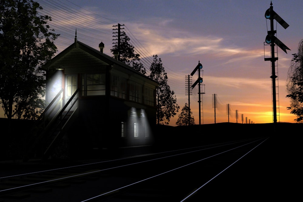a train traveling past a train station at sunset