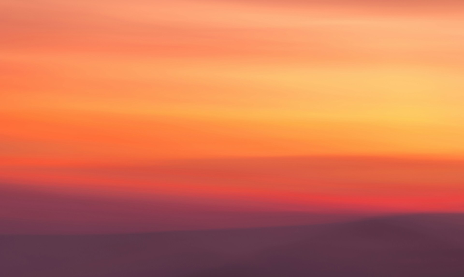 a blurry photo of a sunset with a plane in the foreground