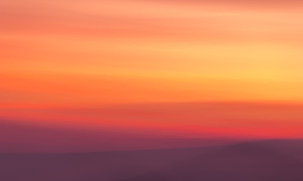 a blurry photo of a sunset with a plane in the foreground