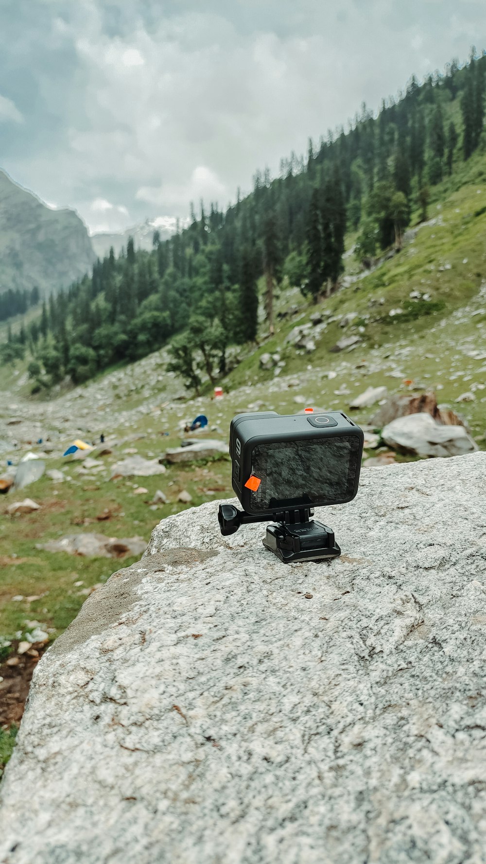 a camera sitting on top of a large rock