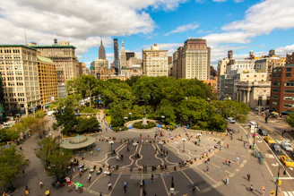 an aerial view of a city square with people walking around