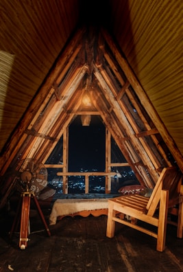 A charming attic room with sloped ceilings, fairy lights, and a small desk by the window.