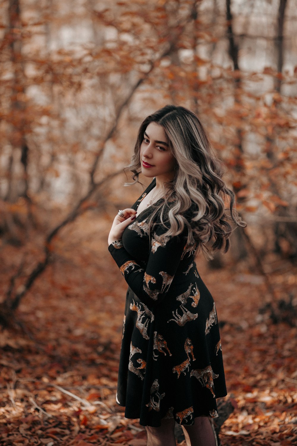 a woman standing in the woods with her hands on her hips