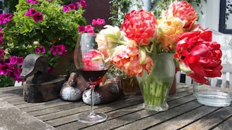 a glass of wine and some flowers on a table
