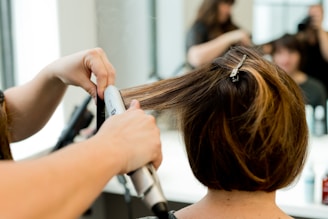 a woman blow drying her hair in a salon