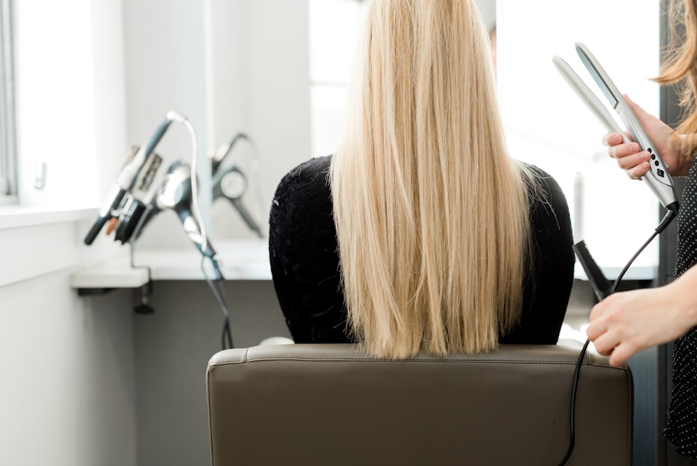 a woman sitting in a chair getting her hair done