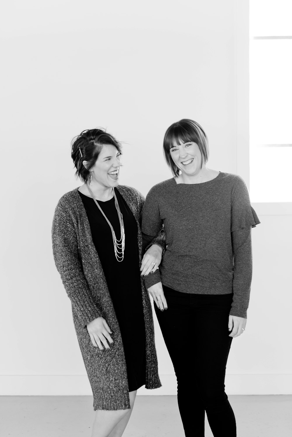 two women standing next to each other in a room