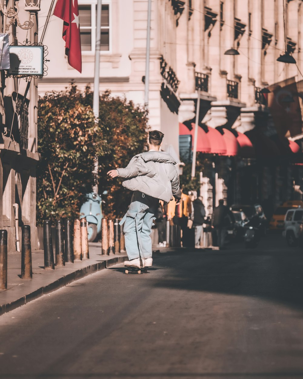 a man riding a skateboard down a street next to tall buildings