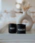 two black cups sitting on top of a white tray