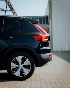 Close-up photo of a sleek black side step installed on a modern SUV.