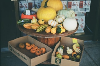 a three tiered display of pumpkins and gourds