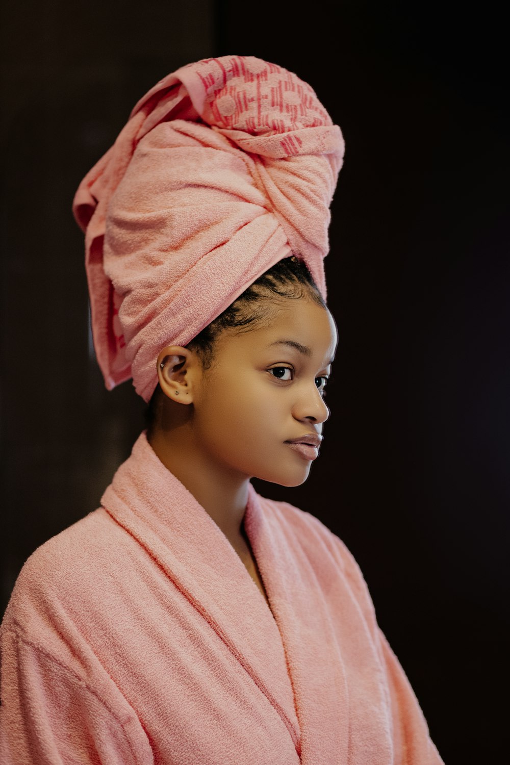 uma menina vestindo um manto rosa e uma toalha rosa