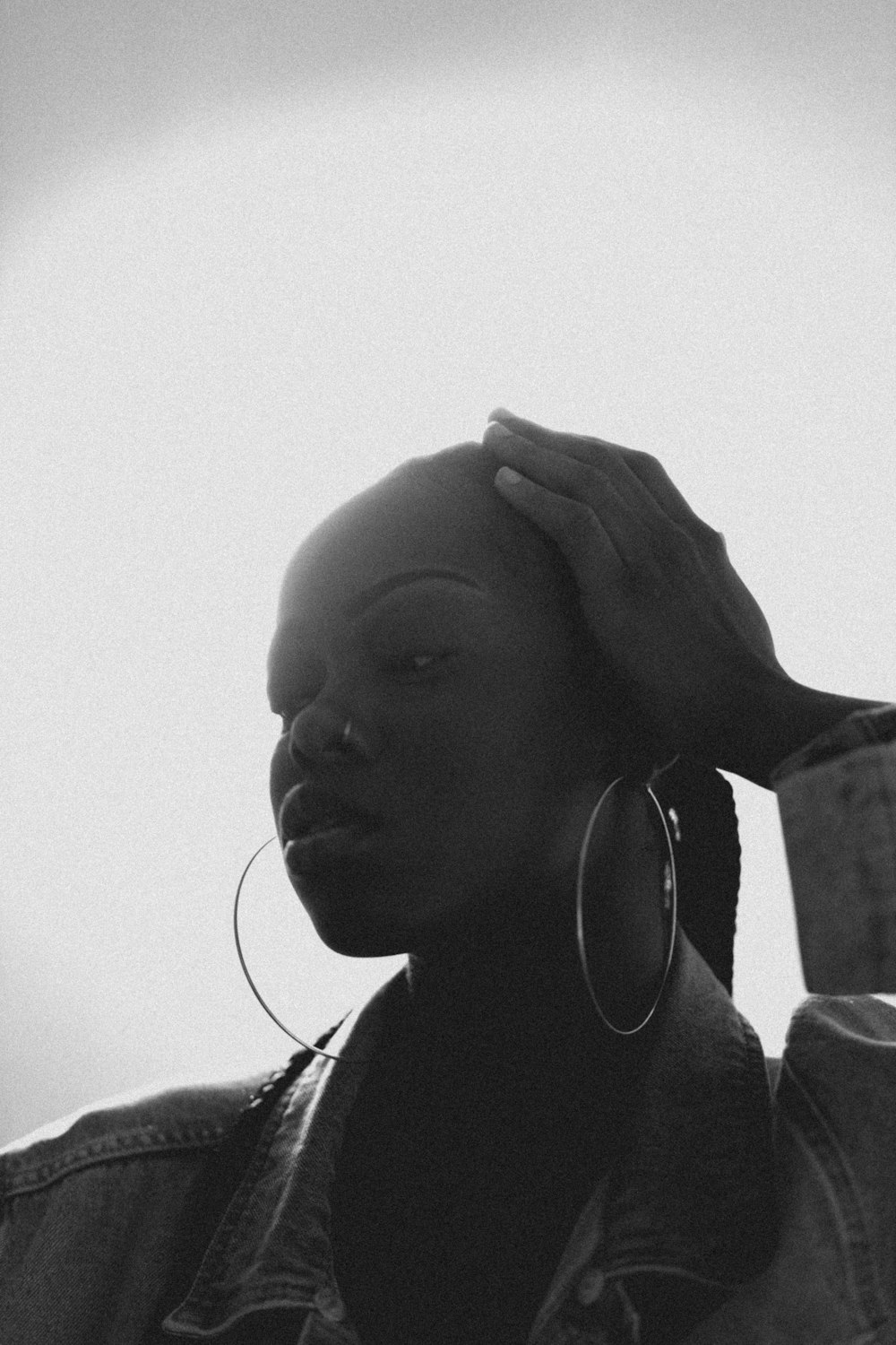 a black and white photo of a woman with large hoop earrings