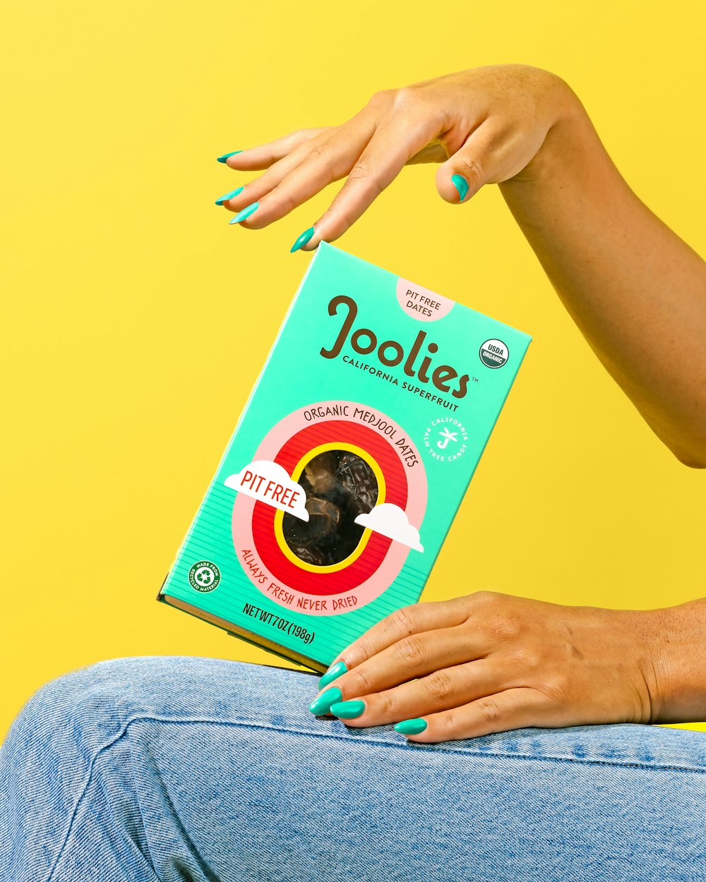 a woman sitting on a chair holding a box of joolies