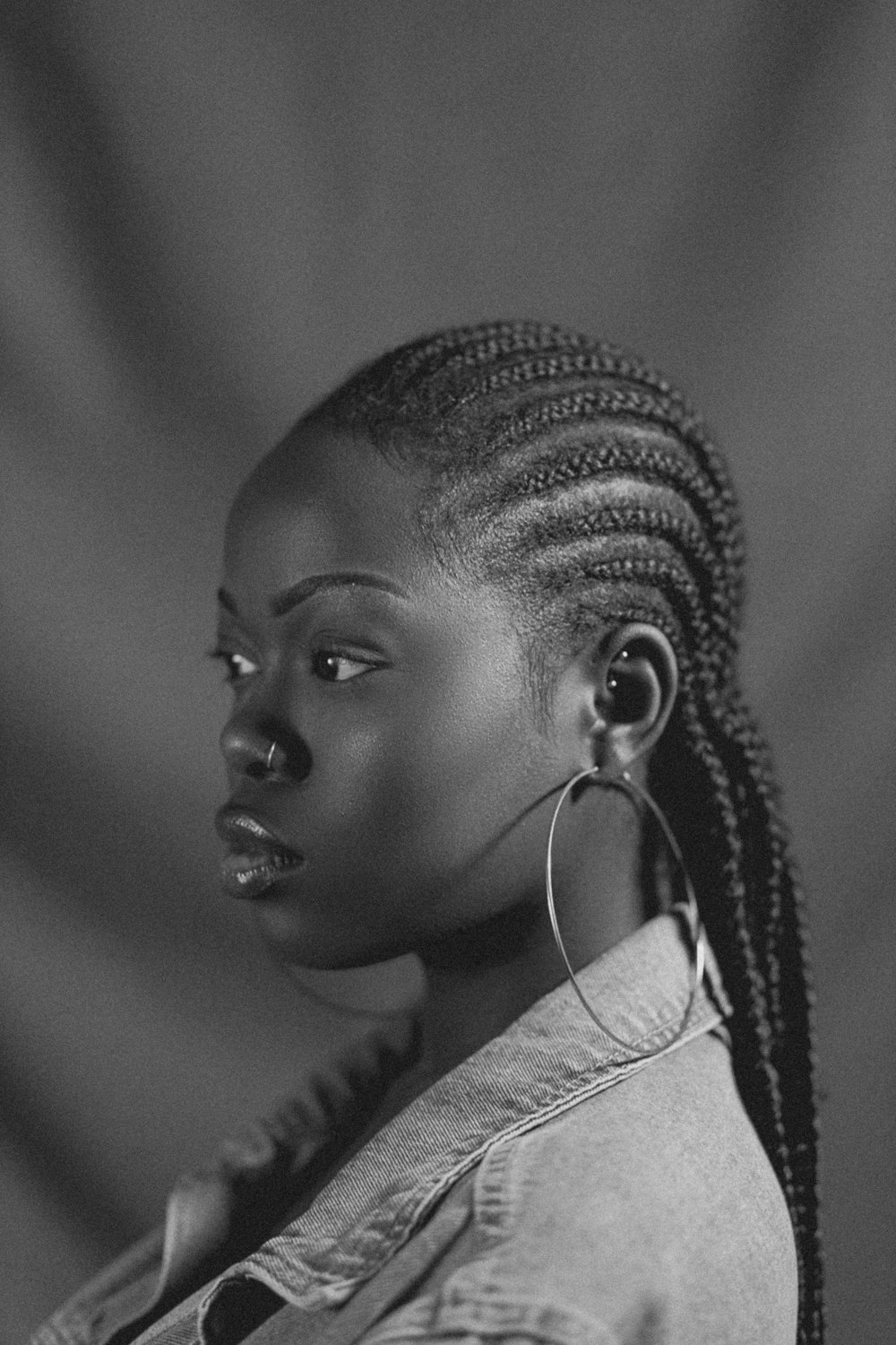 a woman with cornrows and a denim jacket