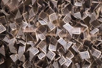 A chaotic arrangement of playing cards with blue and white patterned backs in various orientations, creating a dynamic and intricate visual effect.