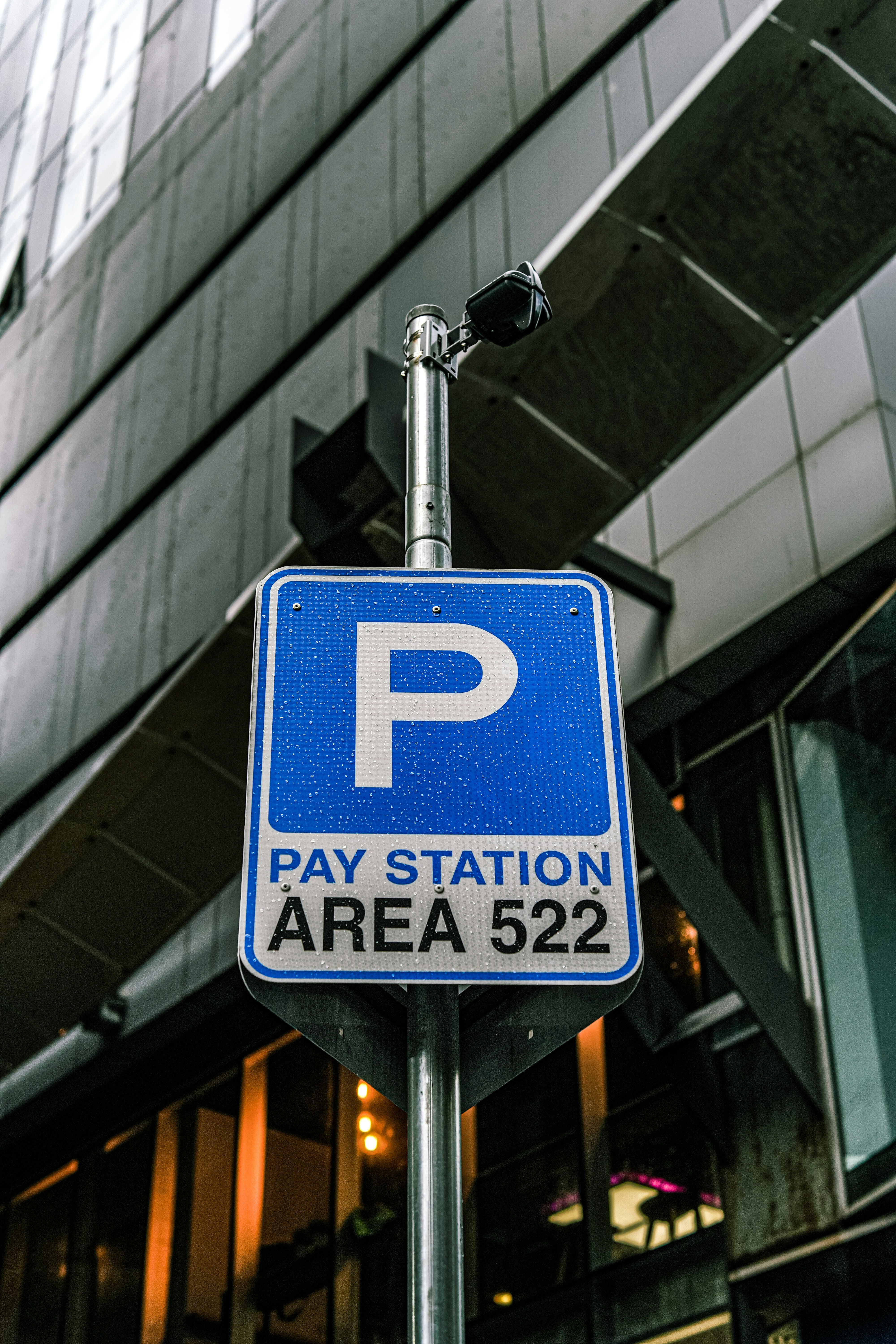 a parking sign on a pole in front of a building
