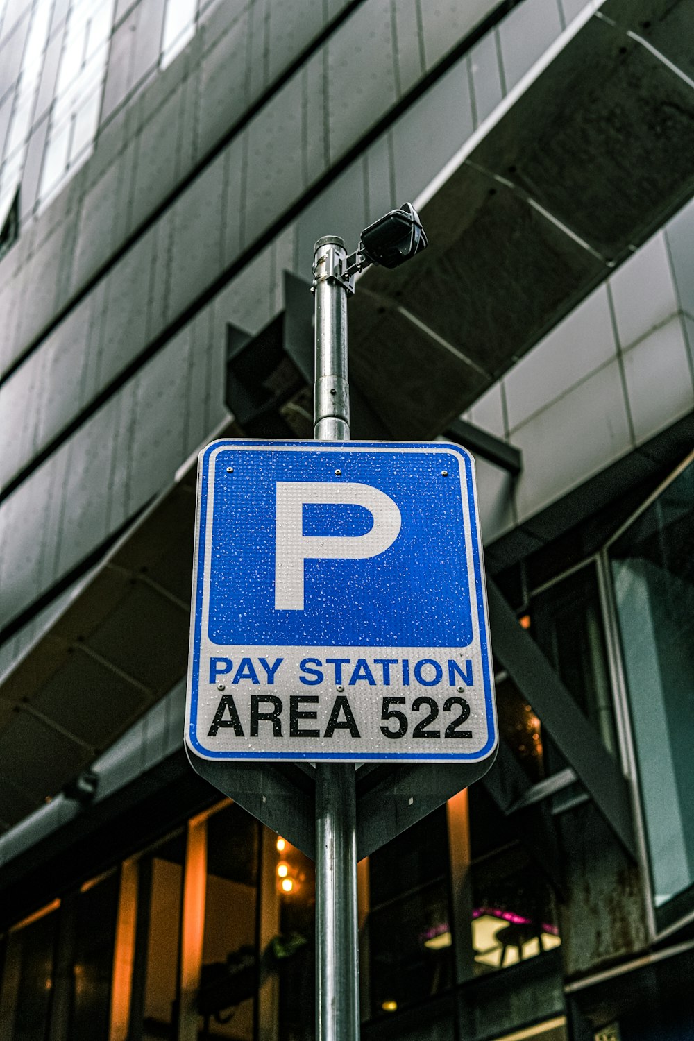 a parking sign on a pole in front of a building