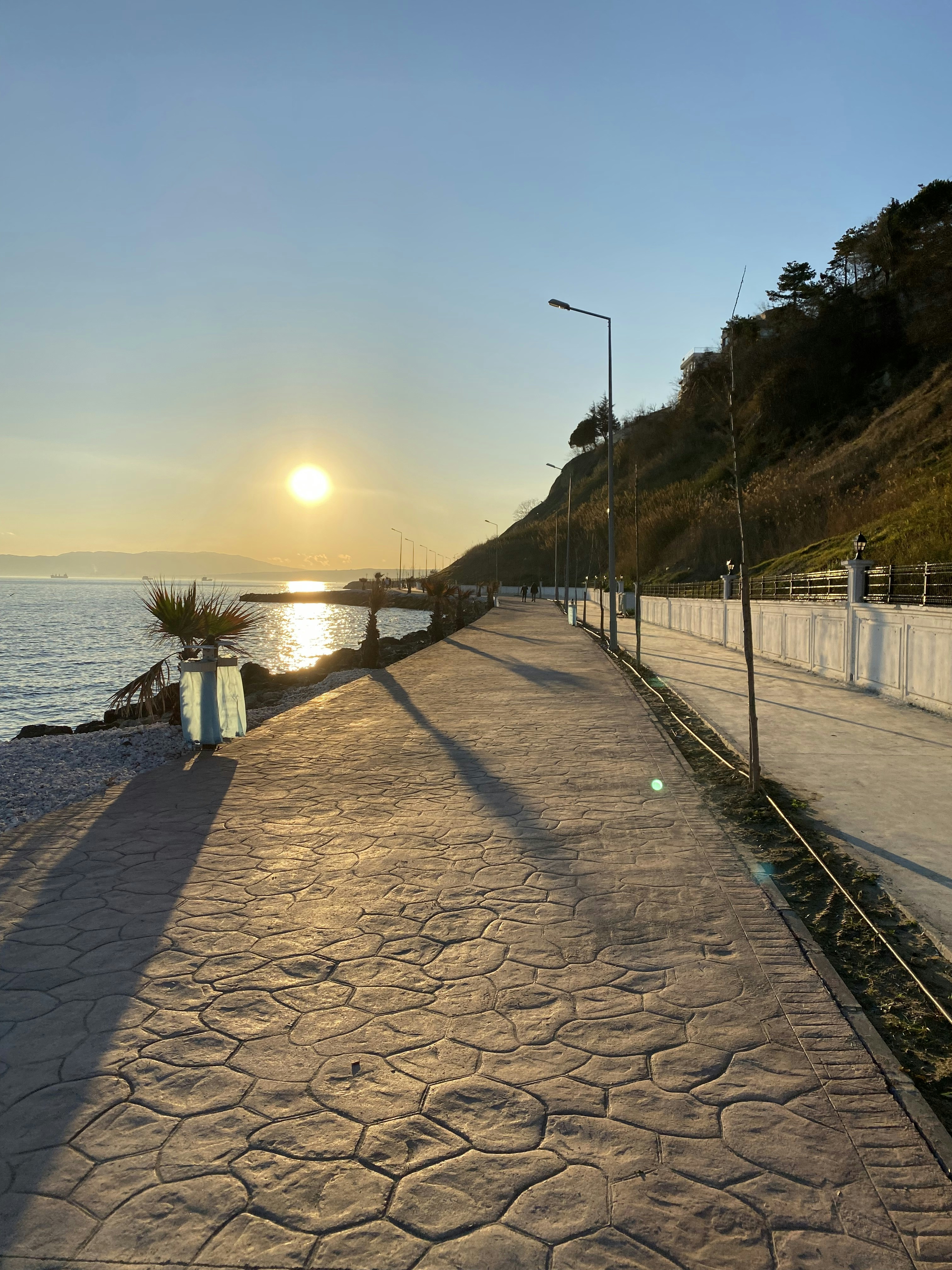 the sun is setting over the water at the beach