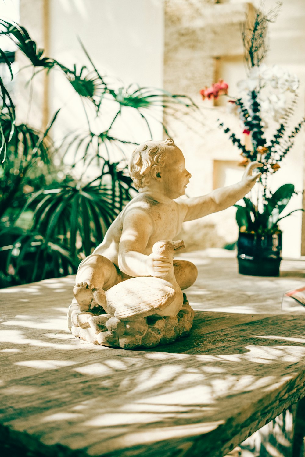 a statue of a boy sitting on a rock