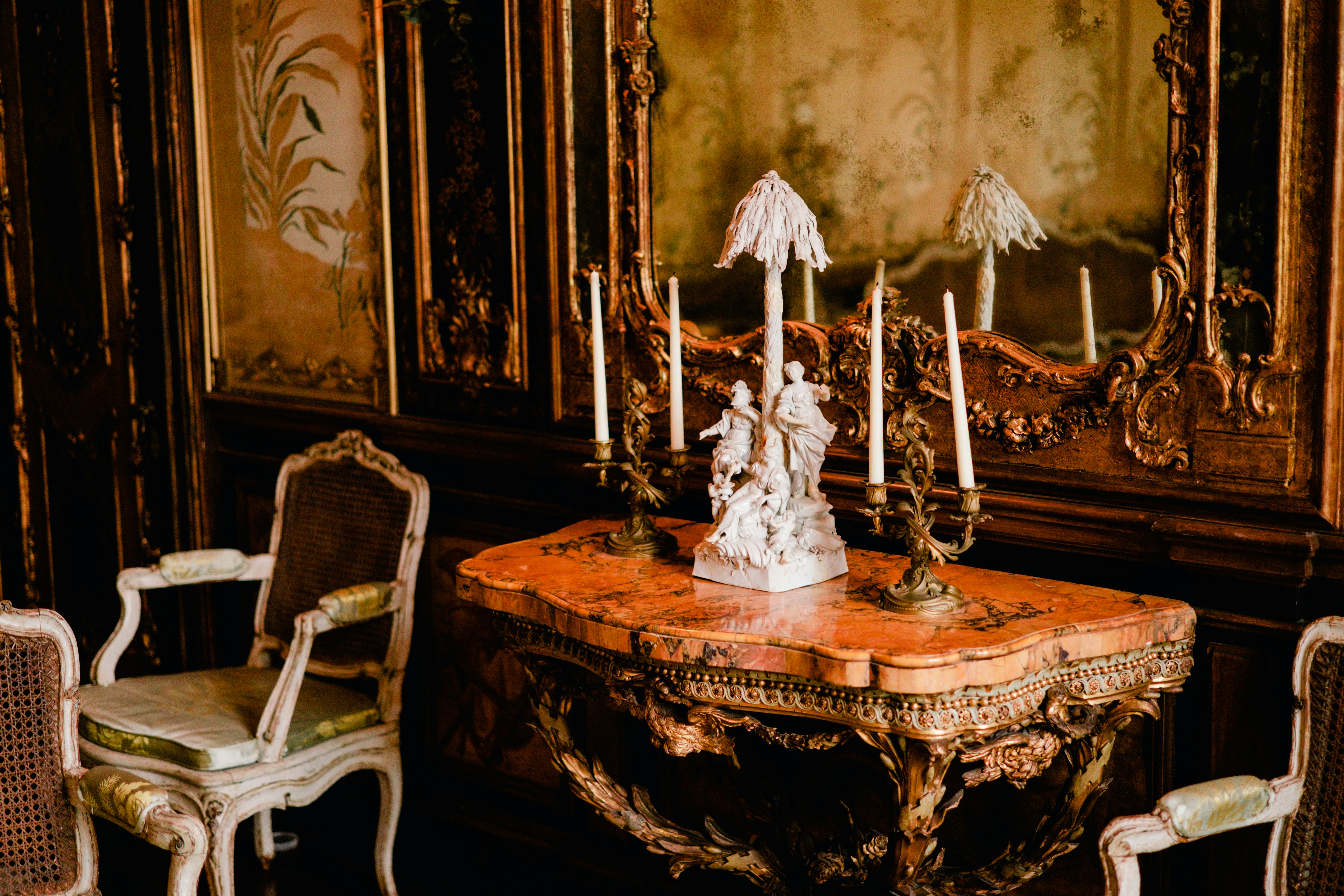 A table with candles and chairs in a room