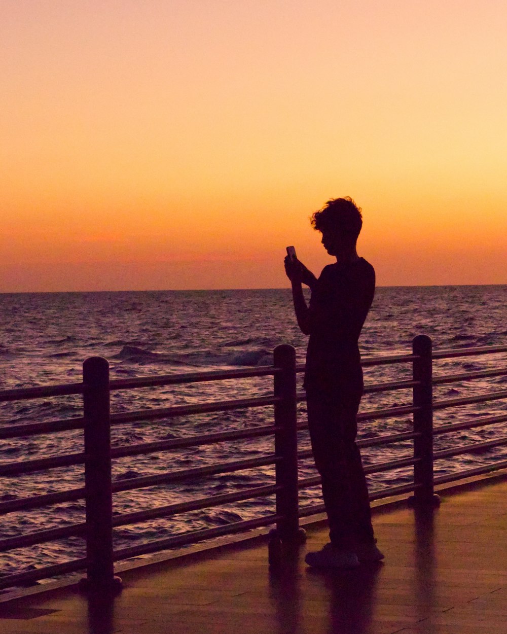 a person standing on a pier with a cell phone