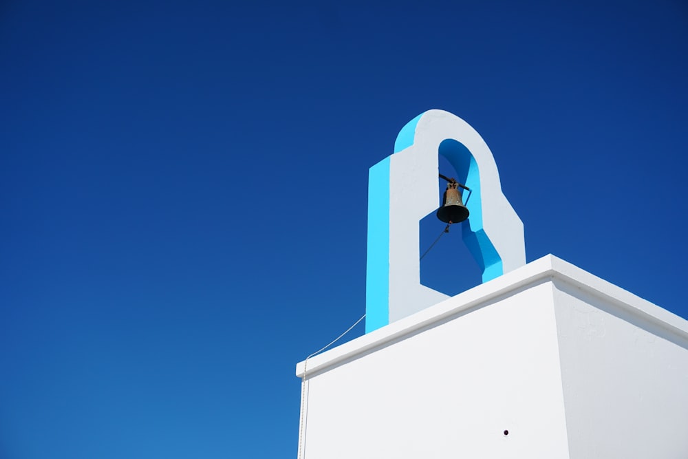 a bell on top of a building with a sky background