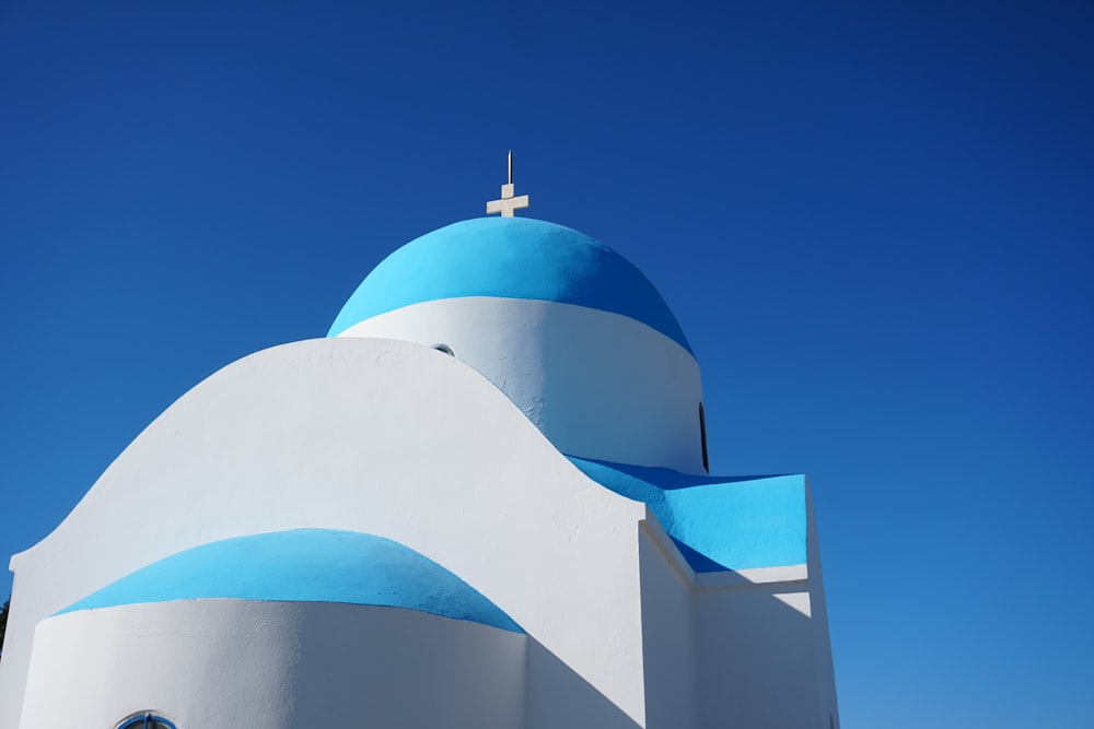 a white and blue building with a cross on top