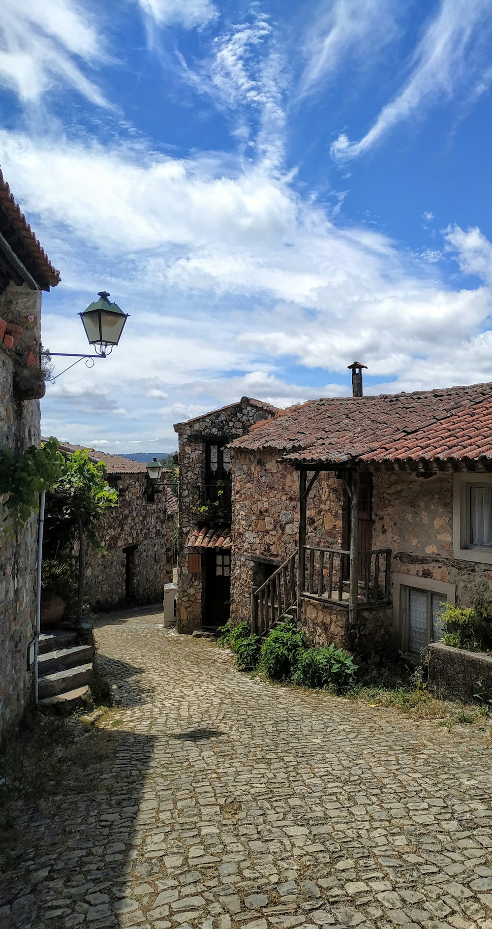 a cobblestone road leading to a stone building