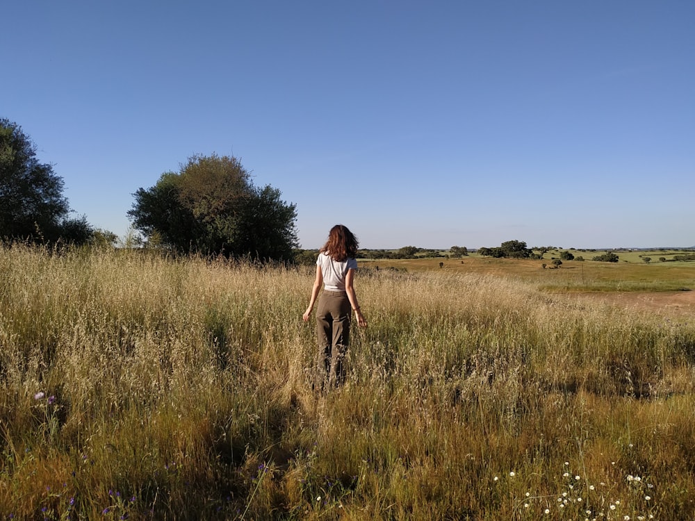 a woman standing in a field of tall grass