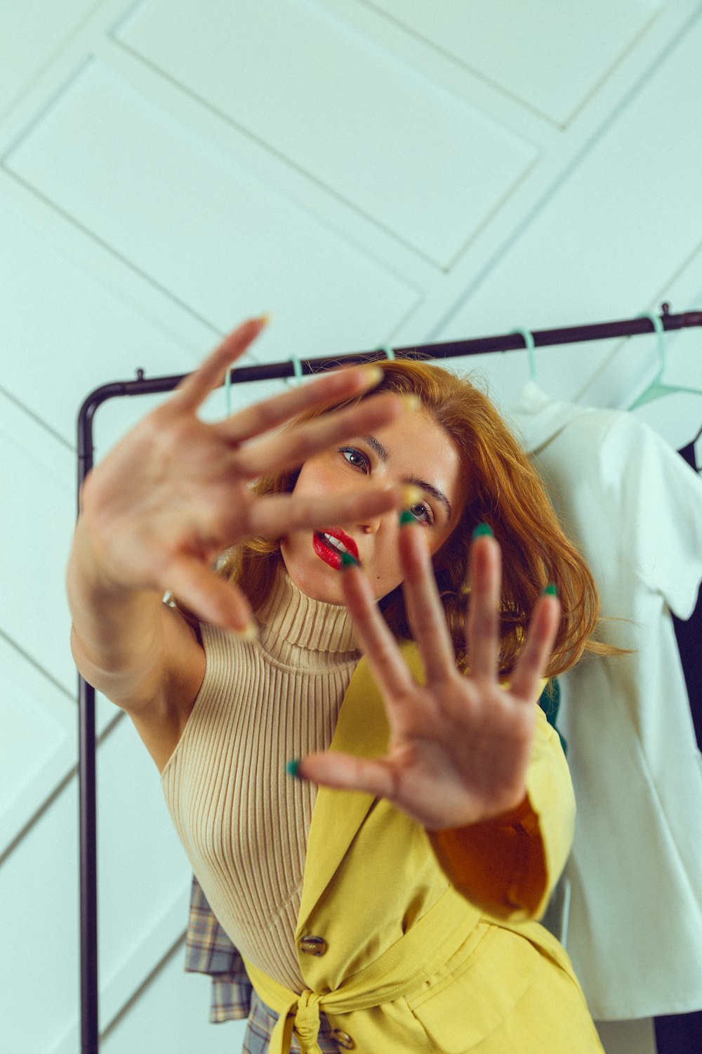 a woman in a yellow dress making a hand gesture