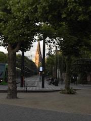 Window view showing a quiet street in Saint-Trond with greenery.