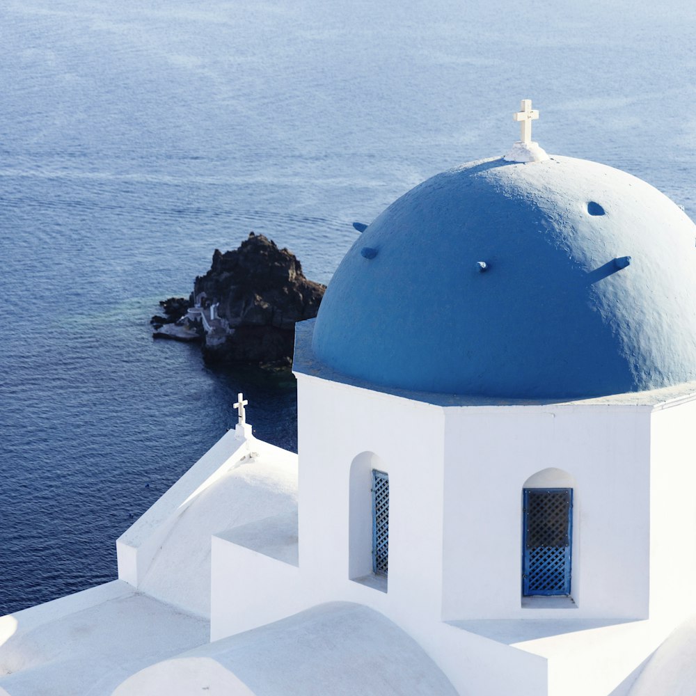 a white and blue building with a cross on top of it