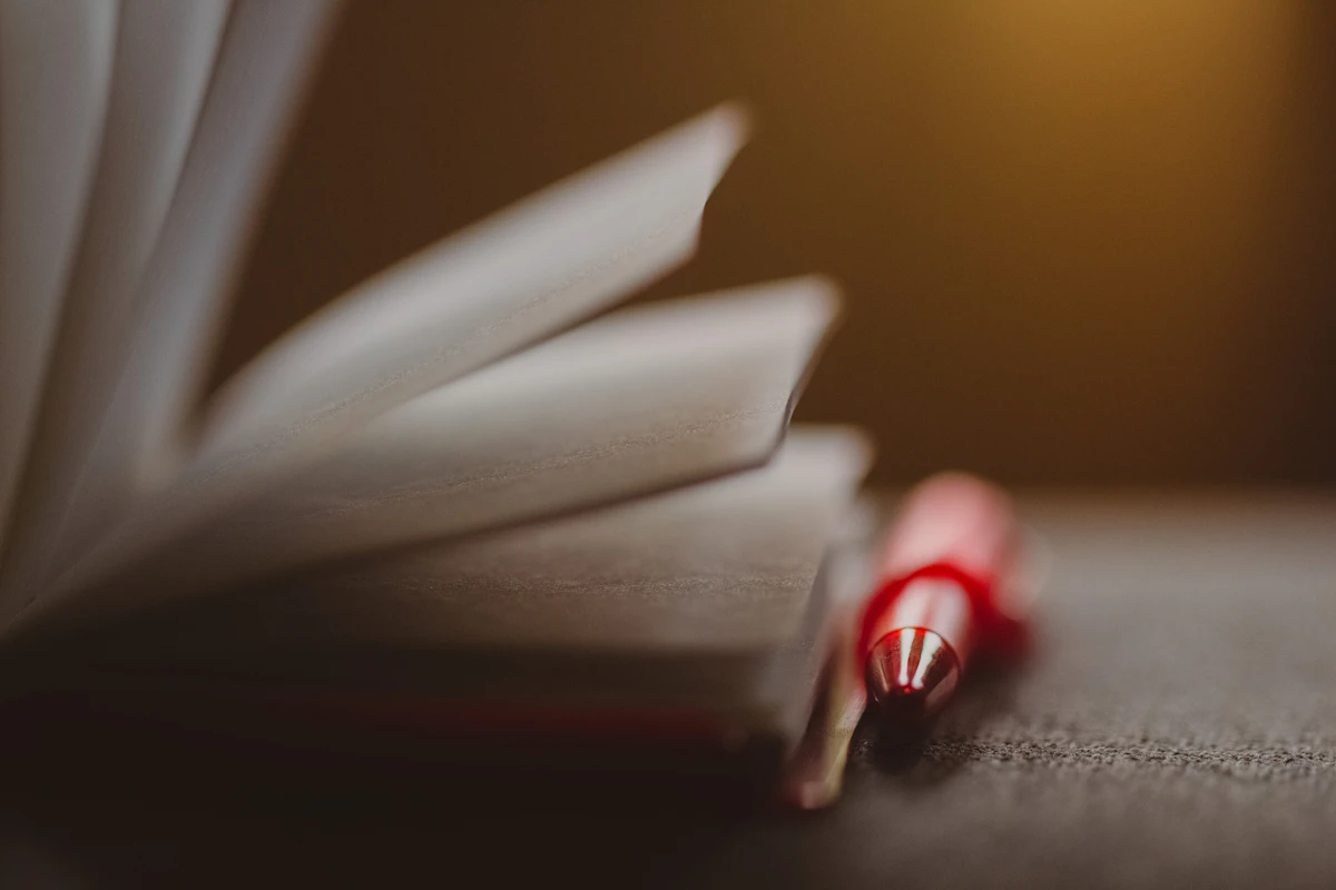 Red pen resting on a notebook