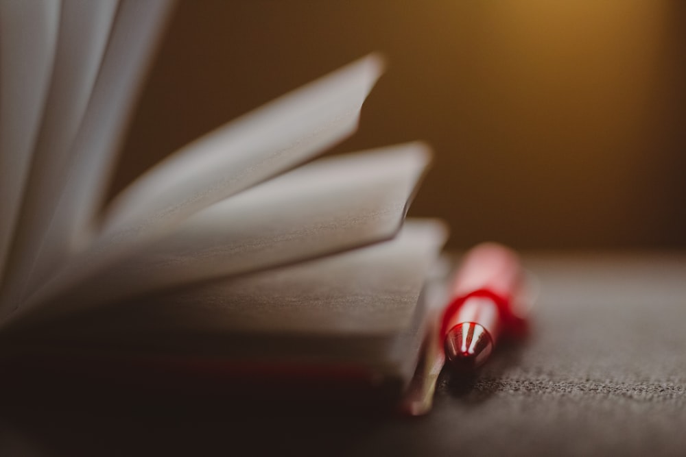 a close up of a book with a red pen