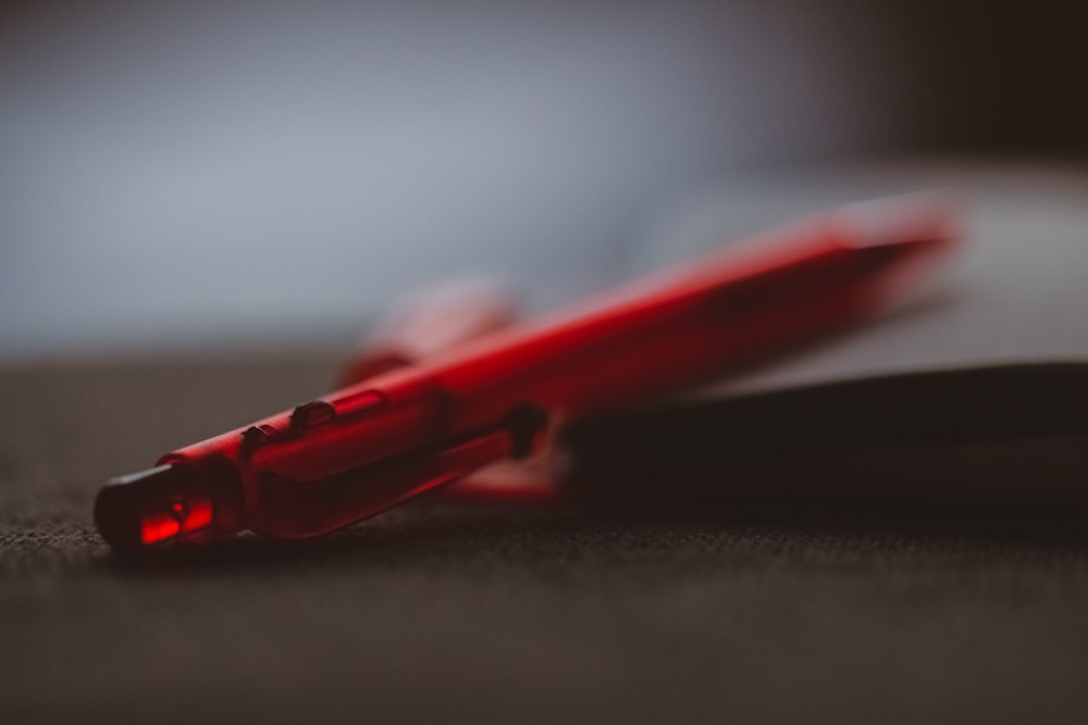 a red pen sitting on top of a book