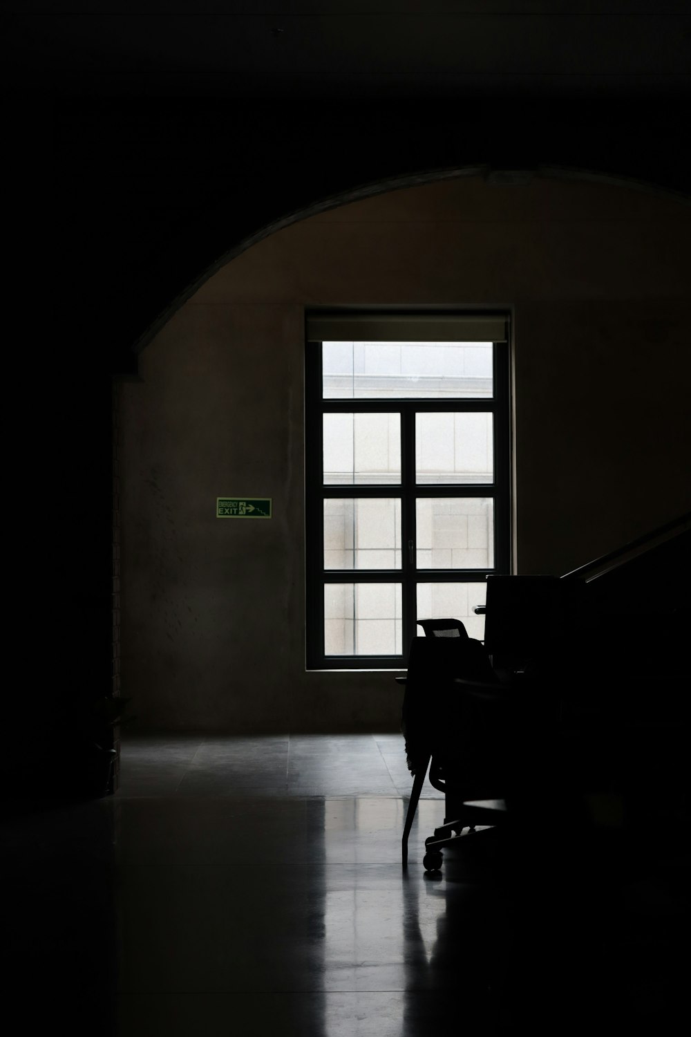 una habitación oscura con una silla y una ventana