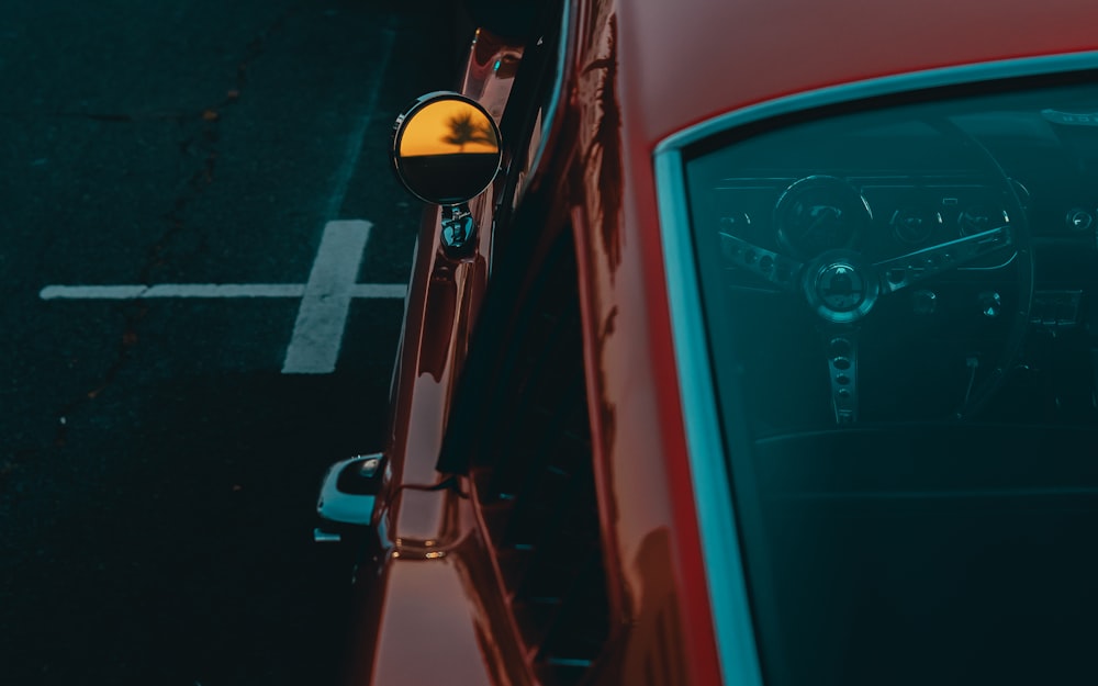 a red car parked next to a parking meter