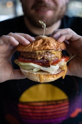 a man holding a hamburger in his hands