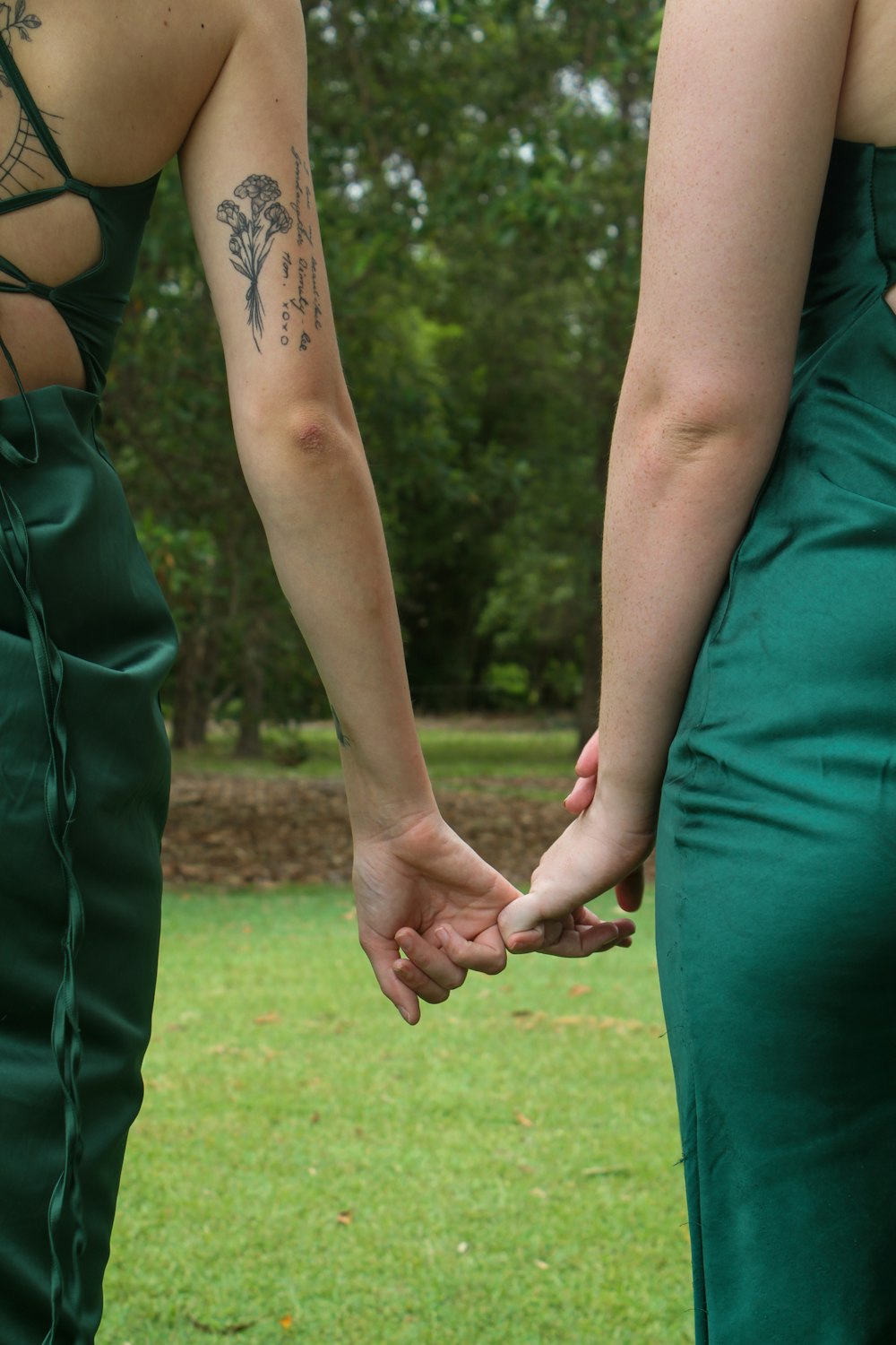 a couple holding hands while standing in a field