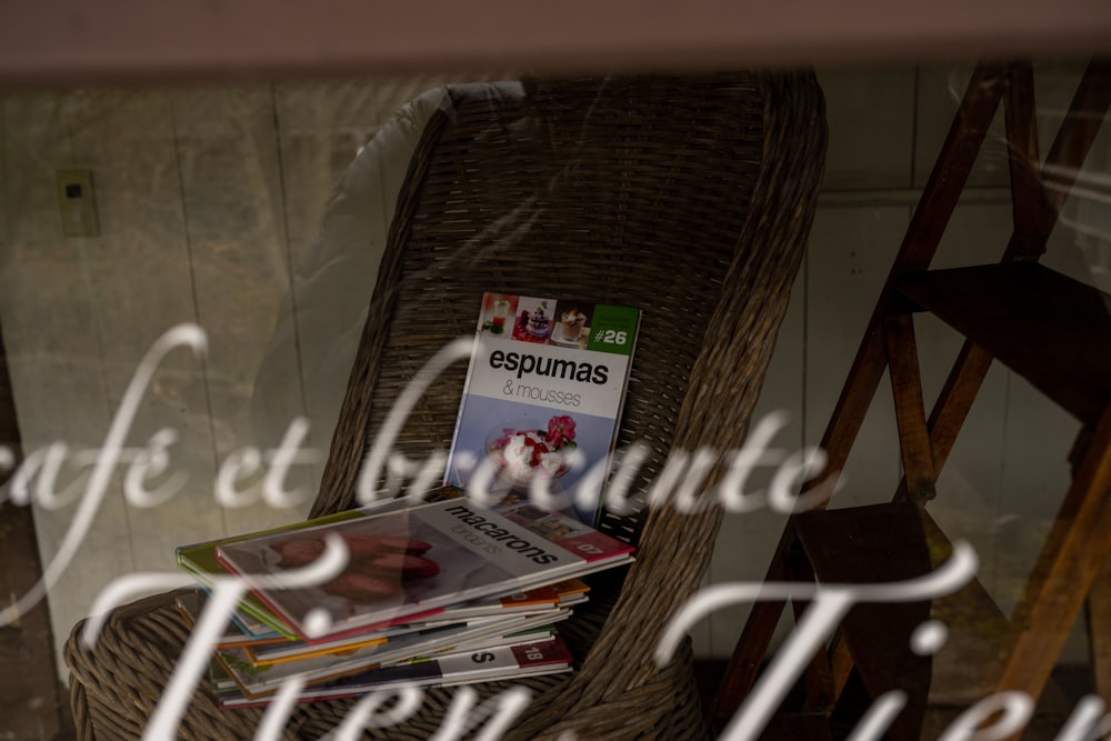 a stack of magazines sitting on top of a wicker chair