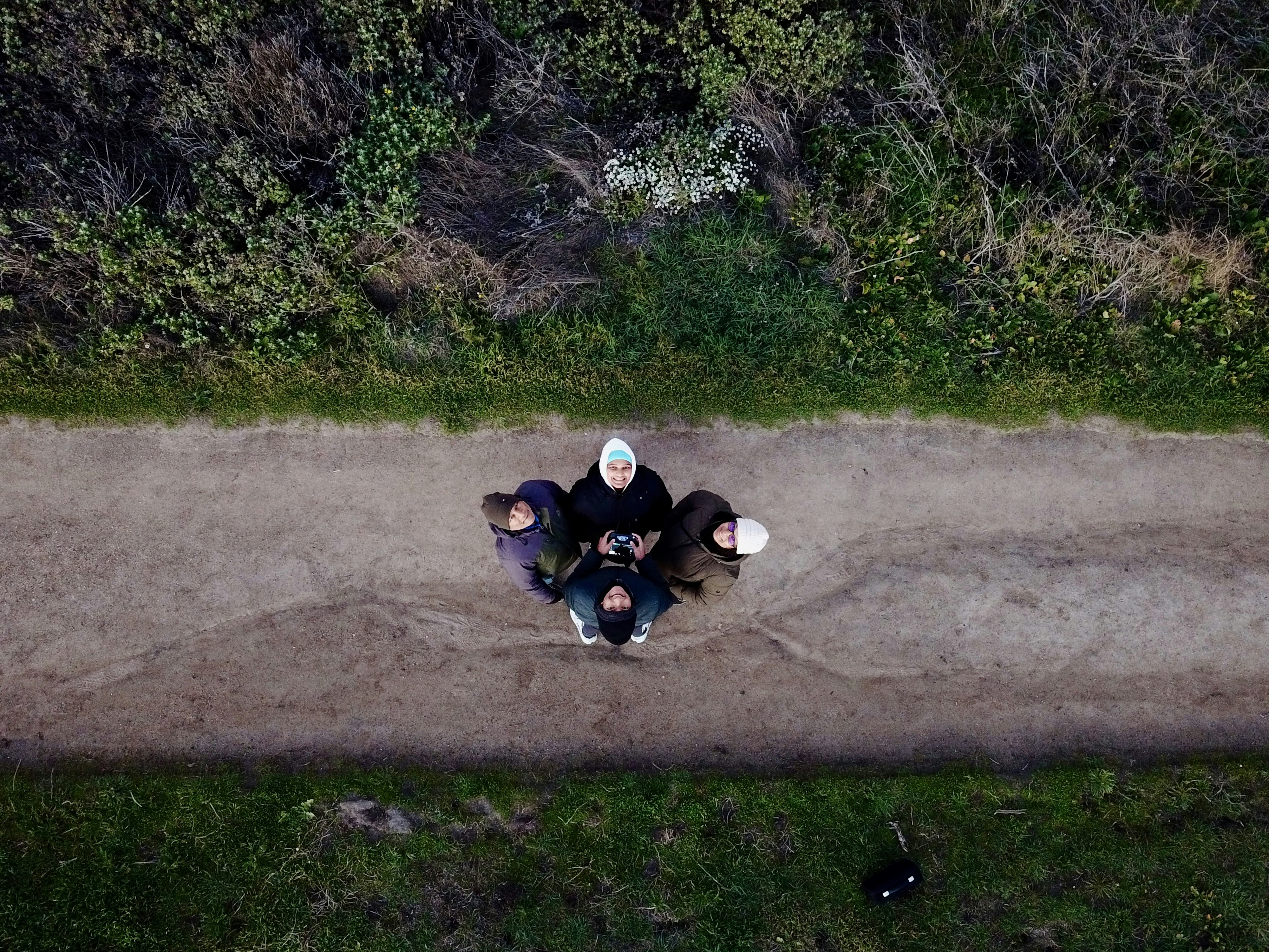 a group of people sitting on top of a dirt road