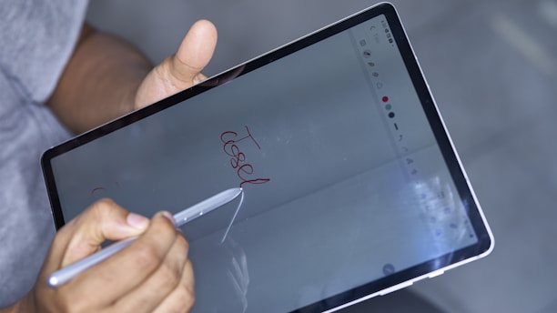 A close-up of a person filling out a form on a digital tablet.