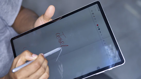 A close-up of a hand clicking a 'submit' button on a digital device screen.