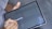 A close-up of hands filling out a loan application form on a tablet.
