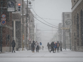 A snowy street in Juneau with news reporters broadcasting live about the approaching blizzard.