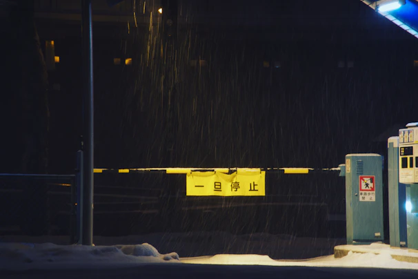 A modern solar-powered parking barrier installed at a residential parking lot on a snowy day.