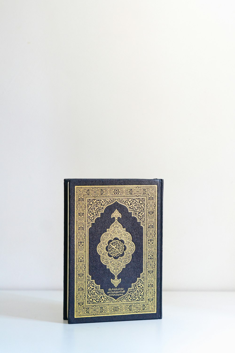 a blue and gold book sitting on top of a white table